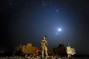 A soldier from Princess of Wales's Royal Regiment stands on 'stag' beneath Venus and jupiter, the two brightest lights in the clear Helmand Province desert sky, Afghanistan