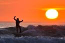 Surfers enjoy the last waves of the day against a backdrop more fitting of Hawai than Woolacombe, North Devon on what has been a fantastic sunny weekend in the UK.