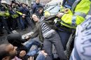 A woman is dragged from the floor by Garda where she was sitting to block the path of a Garda van containing an arrested protester as protesters demonstrate against Tony Blair book signing his memoirs 'A Journey' inside Eason's bookstore on O'Connell Street in Dublin, Ireland