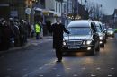 The chief mourner leads the funeral cortege through the High Street