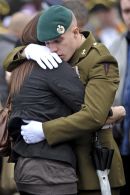 A soldier hugs a woman as they grieve