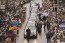 People place flowers on top of the hearse's as six fallen soldiers pass through the Wiltshire town