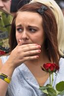 A woman is overcome and reacts as the hearse approaches and the town falls silent