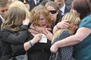 Families hug each other as they grieve on the High Street
