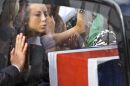 A woman kisses the glass side of the hearse to pay her respects to a loved one